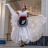 A person in a black and white dress performs a dance