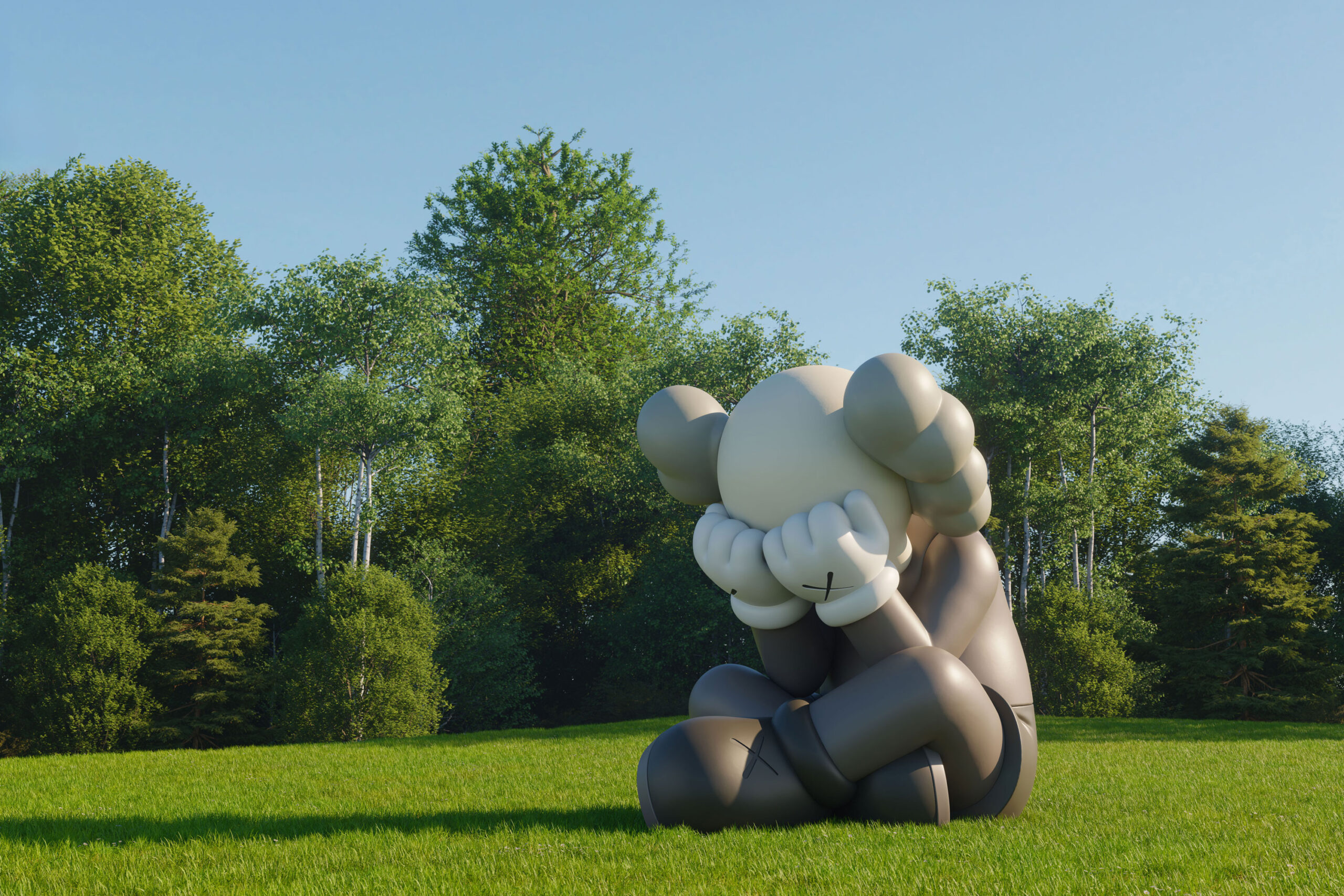 A large gray clown sculpture sits in a sunny green field