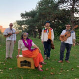 A group of musicians posing for a photo in a field