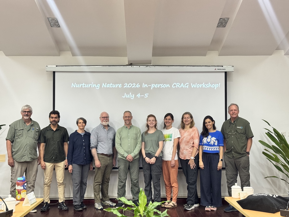 A group of people stand in front of a projector screen
