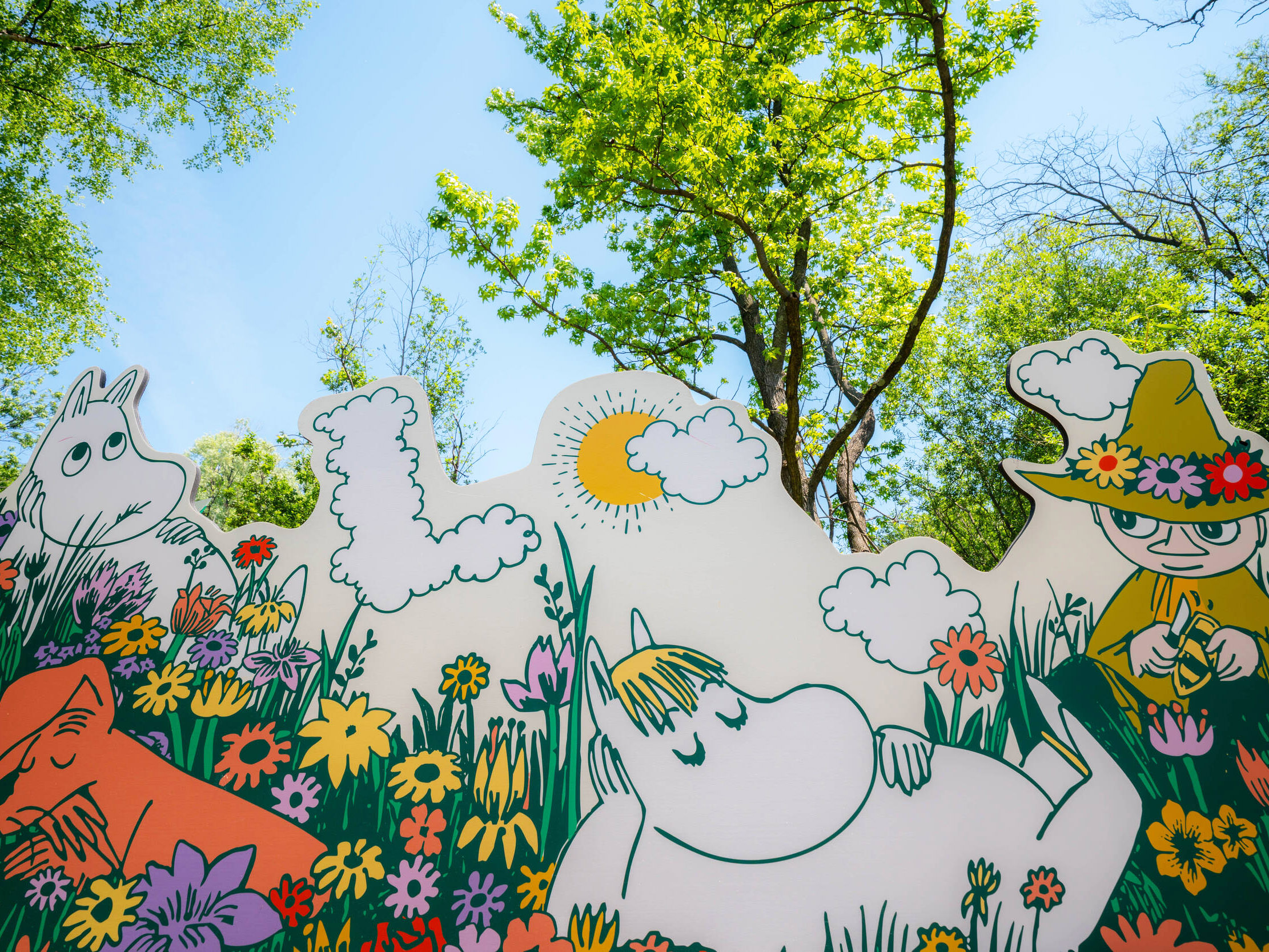 A mural cutout depicting Moomin characters in a flowery setting
