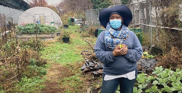 A community gardener talks while standing in the urban farm where she grows fruits and vegetables 